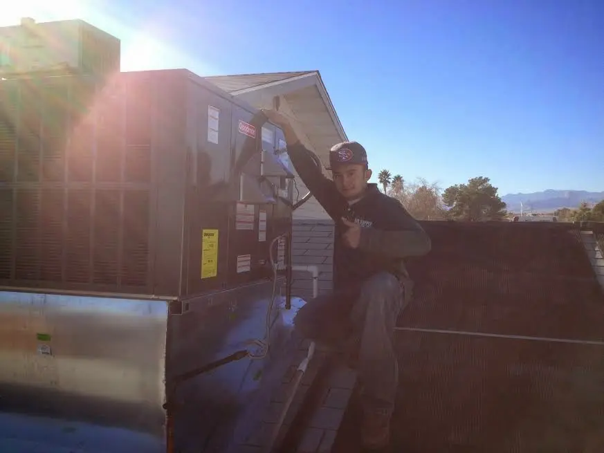 HVAC technician performing Air Duct Cleaning on a rooftop unit in Folsom